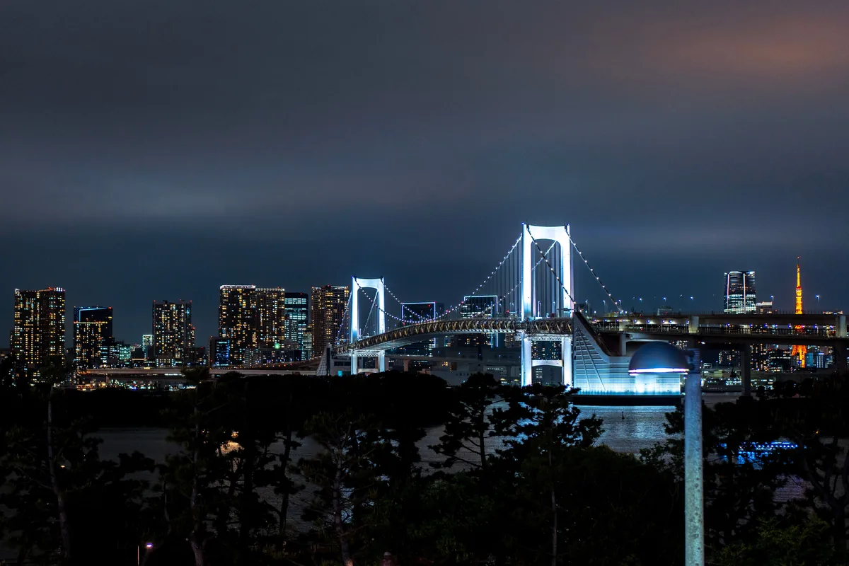 The Rainbow Bridge lit up over Tokyo Bay at night