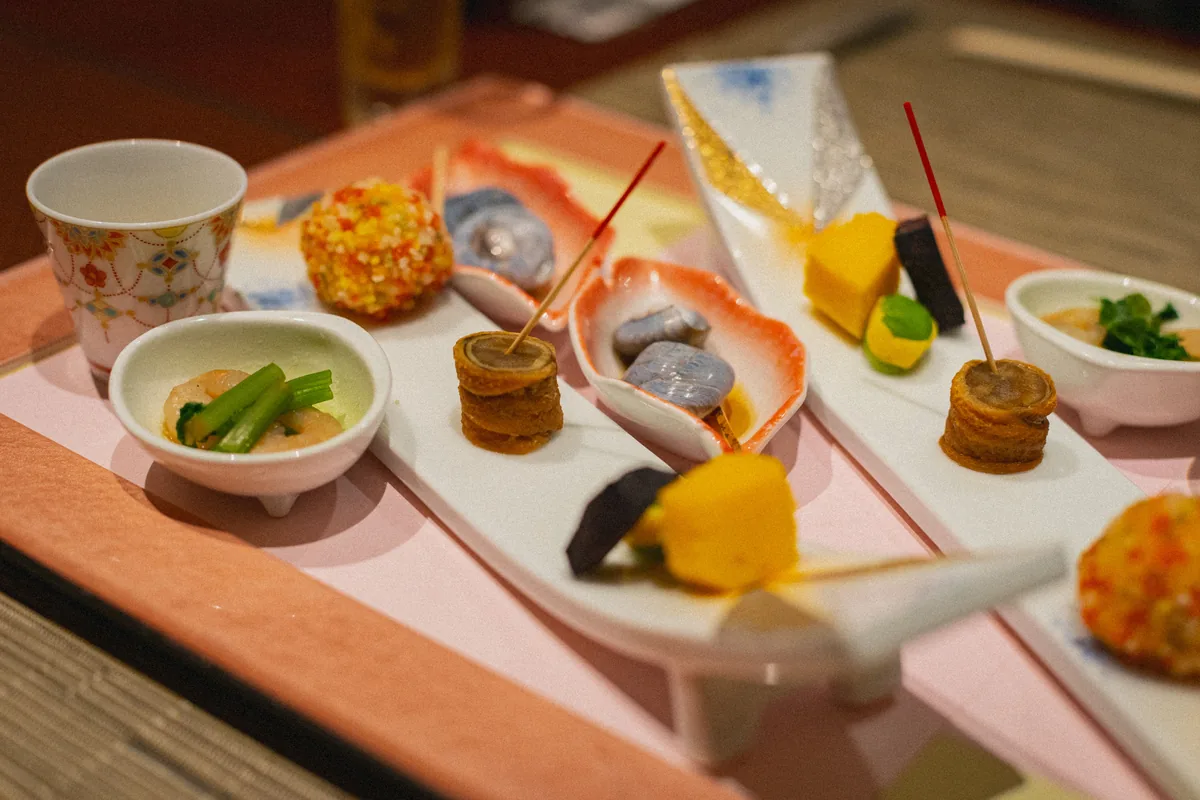 A multi-course Japanese dinner spread of small dishes, representative of the style of meal served on board